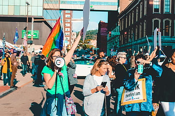 protest, rally, city street, diverse participants, flags, signs, vibrant protest, urban demonstration, public demonstration, street protest, rainbow flag