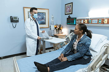 Femme en veste en jean bleu, lit d'hôpital, Professionnel médical, Vérification des patients, milieu hospitalier, médecin, interaction avec les patients, soins de santé, examen médical, chambre d'hôpital, Consultation médicale