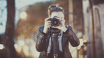 woman holding DSLR camera, young woman photographer, capturing city life, street photography, urban photography, DSLR camera, city street, outdoor photography, female photographer, cityscape photography, street scene