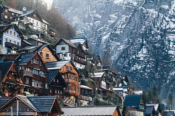 wooden houses, snowy cliffside, Liezen Austria, winter scenery, charming homes, mountain village, assorted-color houses, alpine architecture, rustic houses, winter landscape, snow-covered mountains