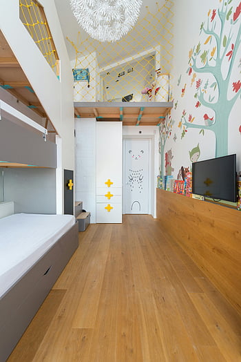 kids room, loft bunk bed, playful decor, colorful illustrations, children room, stylish room, wooden floor, white door, yellow net, wall mural, modern kids room