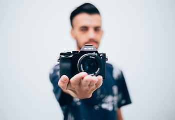 sony dslr aparat fotograficzny, Młody fotograf, trzymając aparat, widok skupiony, fotografia, sprzęt fotograficzny, kamera Sony, męski fotograf, dslr, fotograf trzymający aparat