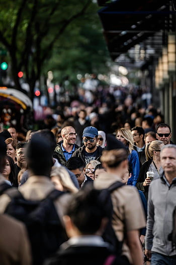 urban scene, diverse people, tree-lined street, bustling city, sidewalk, selective focus, crowd, city life, street photography, public space, urban lifestyle