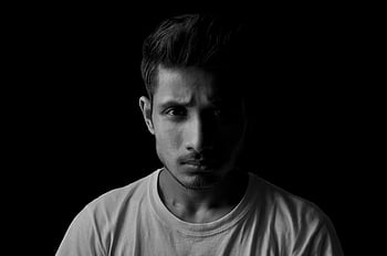 grayscale, close-up, man, crew neck t-shirt, dramatic, black and white, portrait, young man, serious expression, dark background, black and white photography