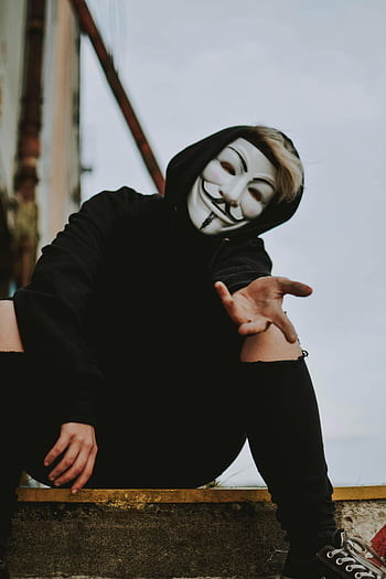 kerel fawkes masker, Hacker Mask, zwarte hoodie, Mysterieus gebaar, buiten instelling, persoon die masker draagt, V voor Vendetta, anoniem masker, stedelijke scène, Casual pose, Street Style