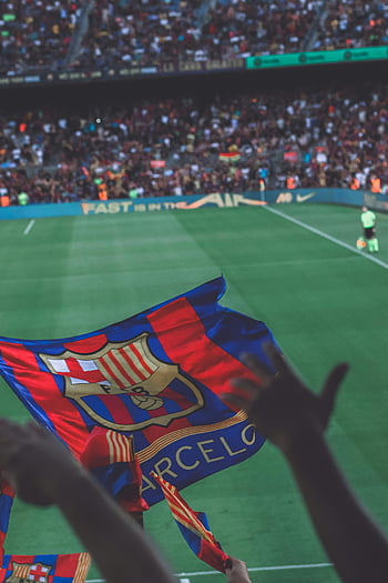 soccer match, Barcelona flag, fans waving flags, vibrant soccer match, stadium in Barcelona, sports event, football game, crowd cheering, team spirit, sports atmosphere, Barcelona FC