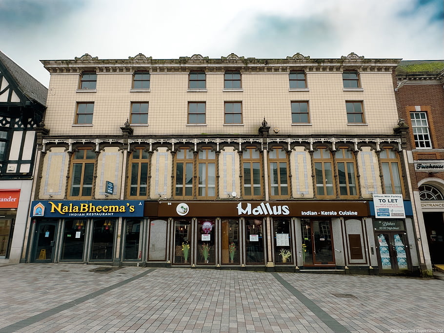 cast iron facade, green tiles, hipped slate roof, elaborate eaves cornice, modillions, sashes, spiral pilasters, modern shopfronts, Grade 2 Listed, Maidstone, 1855 building
