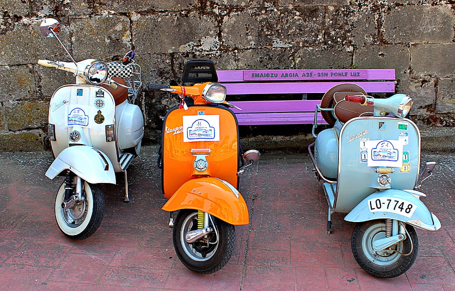 Vespas, classic vehicles, Baños de Ebro, Álava, Spain, meeting, vintage scooters, colorful scooters, purple bench, brick pavement, stone wall