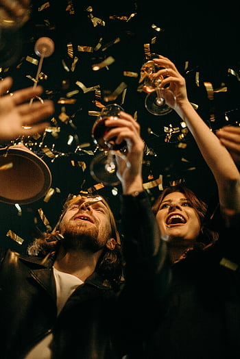 New Year's Eve, party, confetti, wine glasses, group of friends, celebration, drinks, festive, night, cheers, toasting