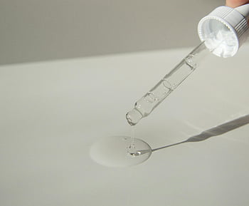 cosmetic pipette, liquid product, serum, pouring, table, soft sunlight, close-up, skincare, beauty, dropper, surface