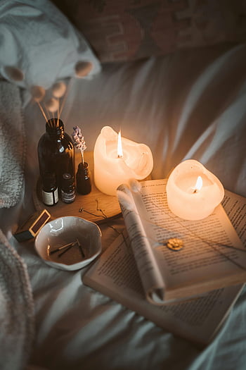 candele, libro bianco, bottiglia di vetro nero, Atmosfera accogliente, illuminazione calda, Invitante camera da letto, luci soffuse, impostazione aromatica, Lettura Nook, Scena di rilassamento, Home decor