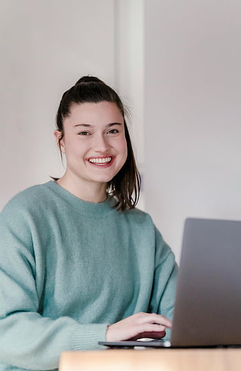 glimlachende vrouw, werken op laptop, Gezellige trui, afstandswerk, moderne levensstijl, vrolijke jonge vrouw, thuiskantoor, laptop werk, werk vanuit huis, Casual werkkleding, thuiswerkruimte