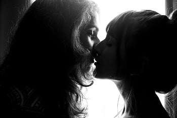 grayscale photography, two women kissing, black and white, intimate silhouette, couple kissing, romance, affection, romantic kiss, black and white photography, grayscale image, intimate moment