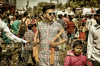 marché indien, marché animé, couleurs vives, homme portant des lunettes de soleil, vêtements blancs et noirs, tenant une écharpe marron, les gens shopping, en interaction, scène de rue, tenue culturelle, habits traditionnels