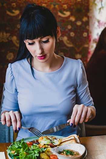 Donna in abito blu, mangiare, cibo salutare, pranzo interno, atmosfera calda, impostazione vibrante, piatto di cibo, tavolo da pranzo, donna che pranza, pasto salutare, vestito blu