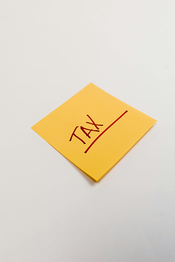yellow sticky note, red ink, tax, finance concepts, white background, marker text, sticky note, yellow note, tax reminder, financial planning, tax concept