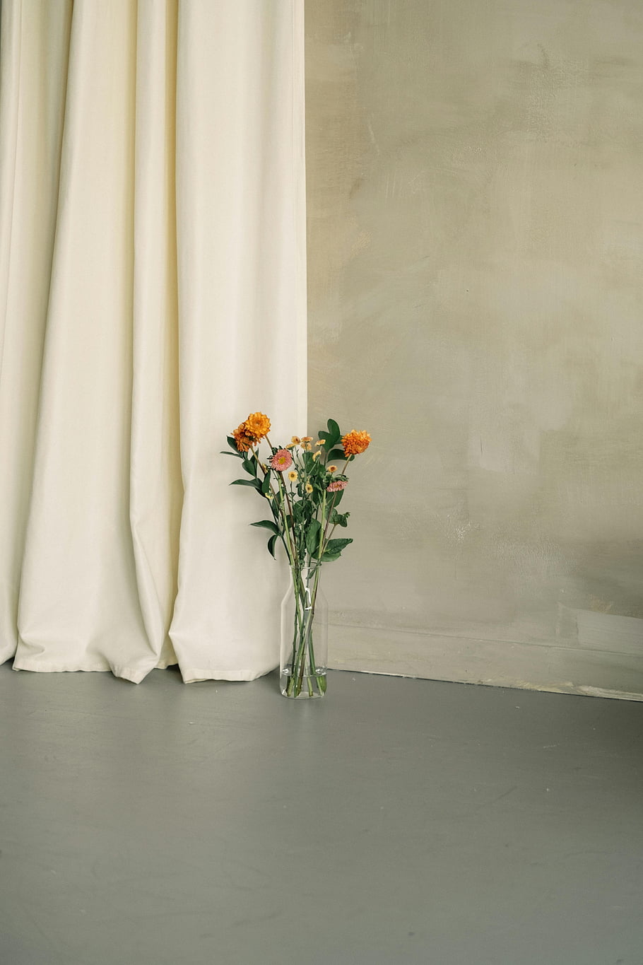 oranžové květy, skleněná váza, moderní dekor, Minimalistický interiér, stojící na podlaze, jasná váza, moderní design, vnitřní květiny, Jednoduchý výzdoba, květinové aranžmá, domácí výzdoba