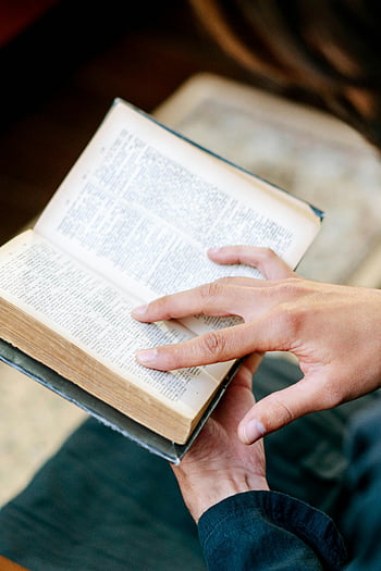 persoon lezen, heilige bijbel, religieus boek, open boek, handen vasthouden, Serene stemming, contemplatieve stemming, close-up foto, spiritueel lezen, Faith Practice, religieuze studie