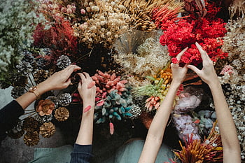 dried flowers, florists, floristry store, vibrant flowers, creative workshop, hands arranging, top view, floral arrangement, dried flower arrangement, workshop setting, floral design