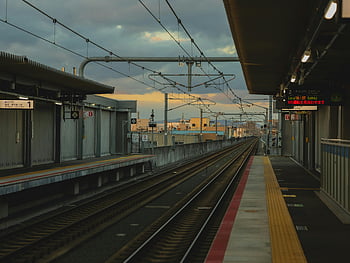 empty railway platform, rails, tranquil railway station, Osaka Japan, twilight hours, train tracks, station platform, urban landscape, evening scene, public transportation, cityscape view