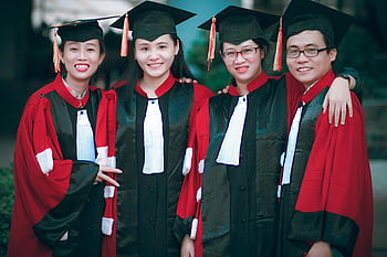 graduation, red-and-black gowns, black mortar boards, happy graduates, outdoor celebration, academic gowns, group photo, success celebration, graduation ceremony, graduation day, graduation party